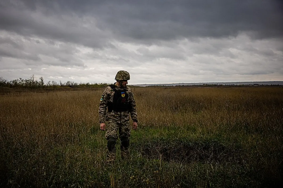 Um militar ucraniano ao lado de uma cratera de morteiro em um campo na região de Donetsk, no leste da Ucrânia, em 24 de outubro de 2022. - Dimitar Dilkoff / AFP